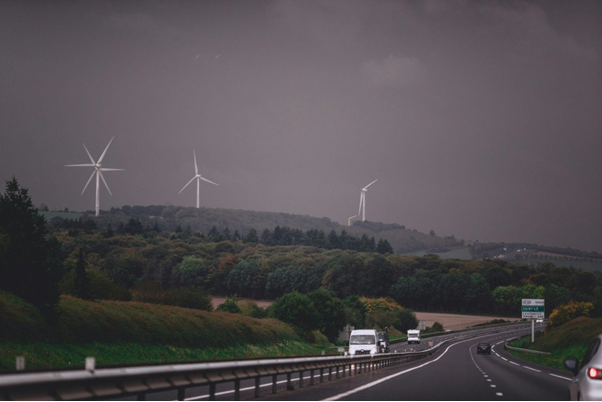 Highway with wind turbines in the background showing sustainable infrastructure planning