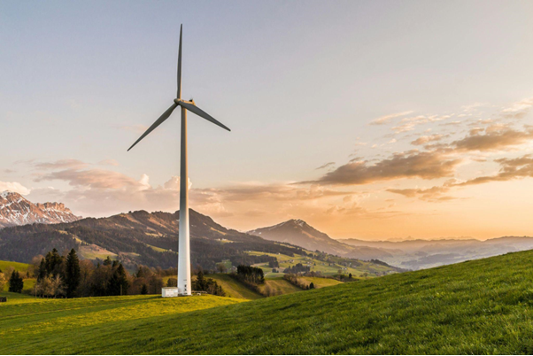 A large wind turbine on a green hill representing clean energy integration in urbanization